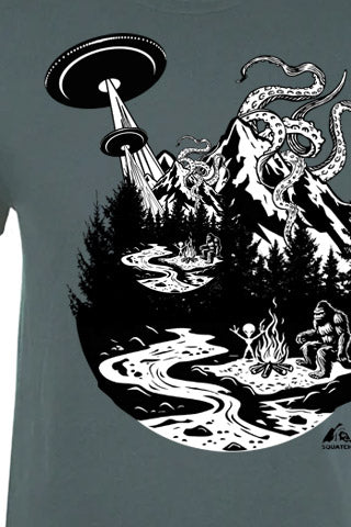 T-shirt with a graphic design of a UFO, alien, and Sasquatch in a forest setting.
Just Another Day Graphic Tee. Black and White on Indigo Tee.  An original design of Just Another Day with Sasquatch, by a fire with his Alien friend, and a Kraken over the Mountain. SQUATCH Industries, Northwest Outdoor Cotton Tees